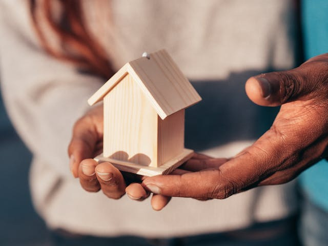 people-holding-mini-house